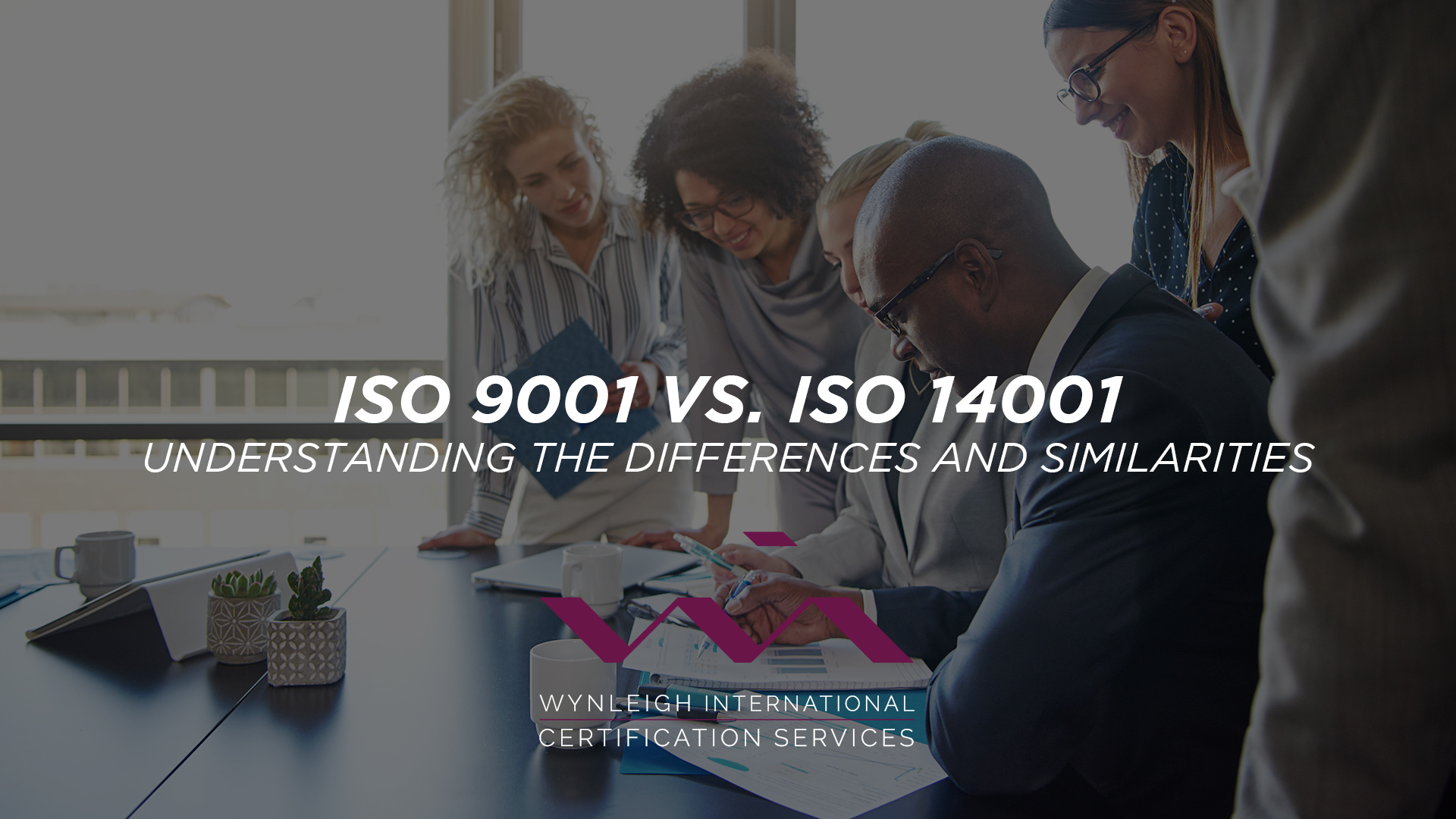 The image shows a team of business people sitting in a meeting. The image is overlaid with the following text: "ISO 9001 vs ISO 14001: Understanding the Differences and Similarities". Wynleigh International's logo is placed beneath the text.