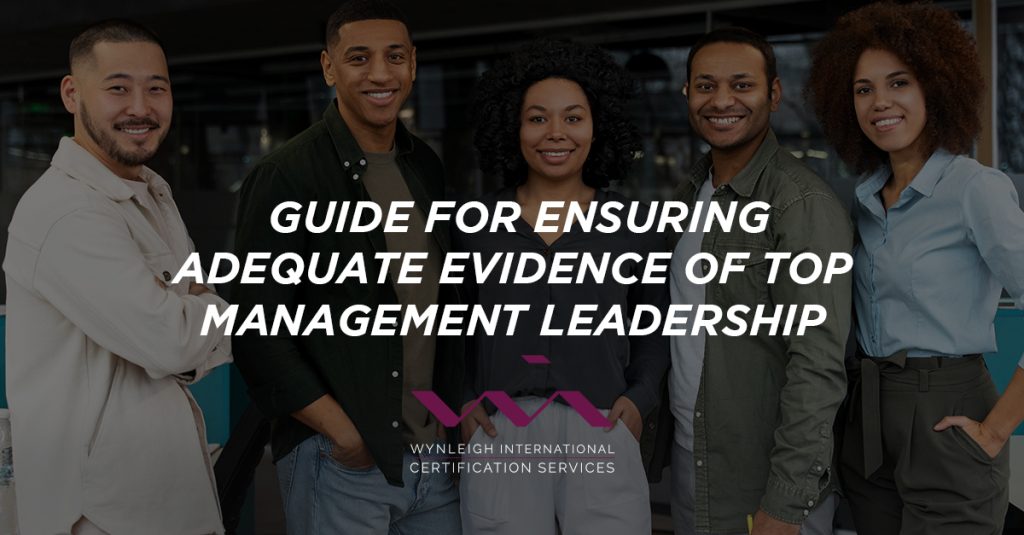 A banner image designed for the Wynleigh International brand. The background image shows a diverse team of business professionals standing, facing the camera. There is a text overlay that reads: "Guide for Ensuring Adequate Evidence of Top Management Leadership"