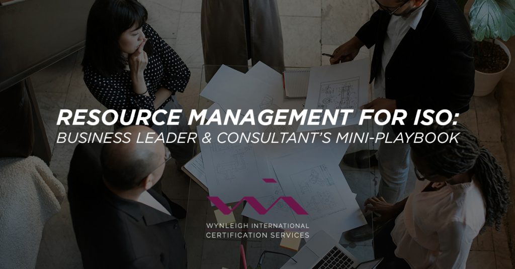 A banner image designed for the Wynleigh International brand. The background image shows a group of business executives standing around paperwork in discussion. There is a text overlay that reads: "Resource Management for ISO: Business Leader & Consultant’s Mini-Playbook"